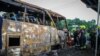 Authorities and firefighters work to remove bodies from the charred bus after a fiery crash that killed 22 students and three teachers, in suburban Bangkok, Oct. 1, 2024.