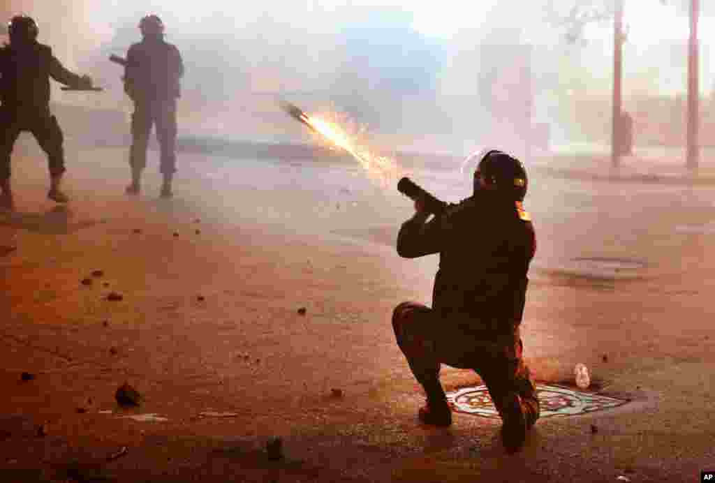 A riot policeman fires tear gas against the anti-government protesters, during ongoing protests against the Lebanese central bank's governor and the deepening financial crisis, at Hamra trade street, in Beirut, Lebanon, Jan. 14, 2020.