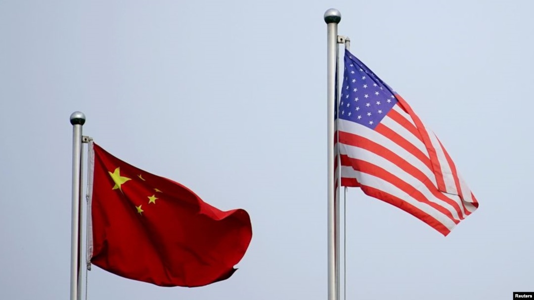 資料照：美中兩國國旗在中國上海的一家公司大樓外飄揚。 （2021年4月14日）