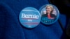 A demonstrator wears Democratic presidential candidate's buttons.