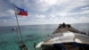 FILE - A Philippine flag flutters from BRP Sierra Madre, a dilapidated Philippine Navy ship that has been aground since 1999 and became a Philippine military detachment on the disputed Second Thomas Shoal in the South China Sea, March 29, 2014.