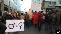 ARCHIVO - Una activista lleva un cartel que promueve la igualdad de género en un mitin en Rabat, Marruecos.