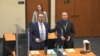 En esta imagen tomada del video, el abogado defensor Eric Nelson, izquierda, acusado y ex oficial de policía de Minneapolis Derek Chauvin, derecha, y la asistente de Nelson, Amy Voss, se presentan ante posibles miembros del jurado el 23 de marzo de 2021.