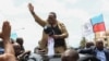 Tanzanian opposition leader Tundu Lissu waves to supporters after he returns from exile, as his vehicle moves through the streets of Dar es Salaam, Tanzania, Jan. 25, 2023. 