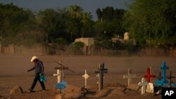 Un indígena yaquí cruza un cementerio donde se encuentra sepultado Tomás Rojo, un activista defensor del agua que fue asesinado, el martes 27 de septiembre de 2022, en Pótam, estado de Sonora, en el noroeste de México. (AP Foto/Fernando Llano)