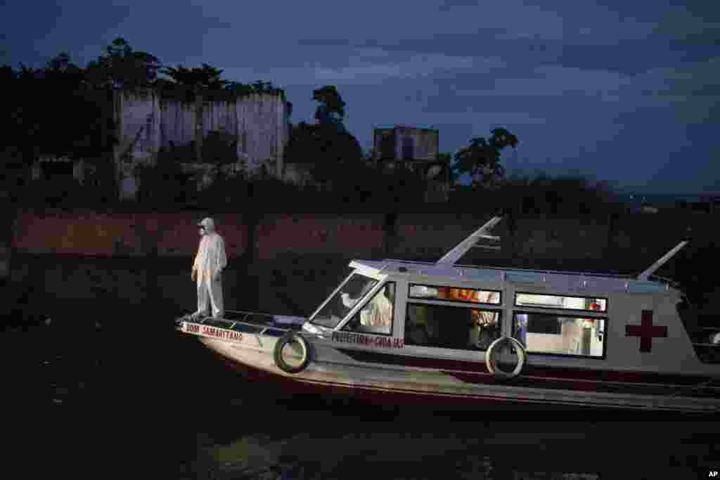 A health worker stands on a boat carrying COVID-19 patient Jose da Conceição as he waits for an ambulance to transfer him to a hospital after arriving in the port of Manacapuru, Amazonas state, Brazil, June 1, 2020.