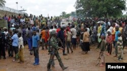 Residents gather outside the UN base to protest the killings of two locals earlier in the morning in Beni in North Kivu province, DRC, Oct. 22, 2014.