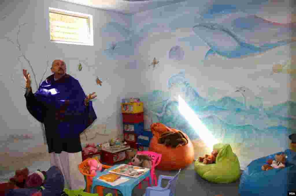 Hospice psychologist Cameron Hogg shows off murals in a pastel-filled Wits Hospice playroom. Opposing walls are filled with African elephants lumbering toward a burnt-orange sunset. (Photo by Darren Taylor) 