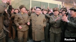 지난 3월 서해위성발사장에서 신형 고출력 로켓엔진 지상분출시험을 참관한 북한 김정은 국무위원장(가운데)이 관계자들과 함께 환호하고 있다.