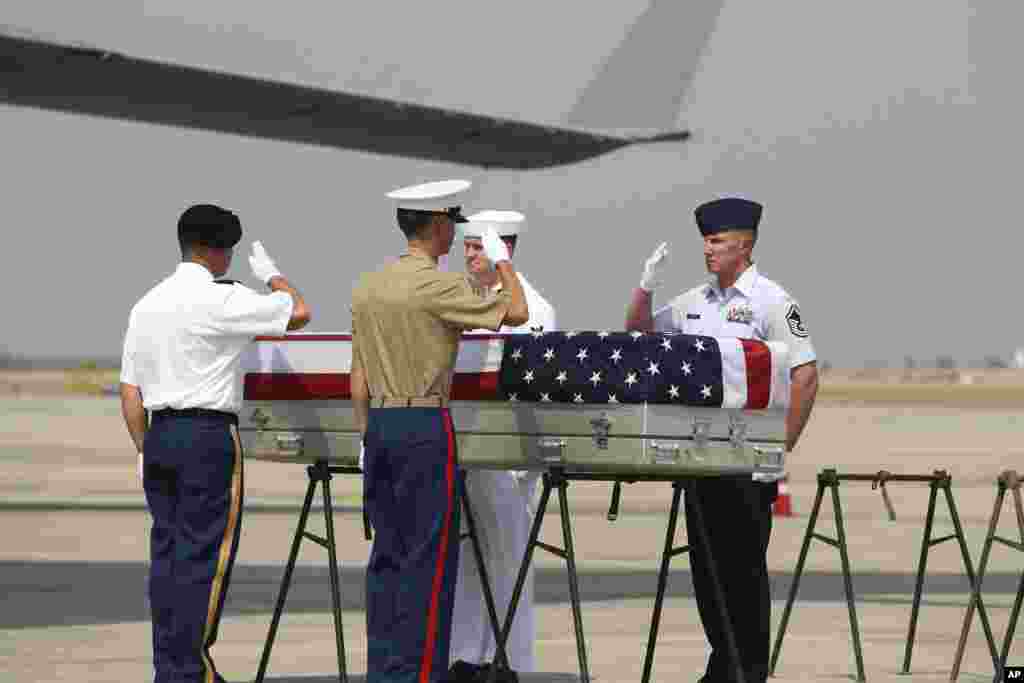 U.S. military guard of honor salute a coffin covered with U.S. national flag during a repatriation ceremony at Mandalay International Airport in central Myanmar. The U.S. military has repatriated what may be the remains of service personnel who were lost in action during World War II.