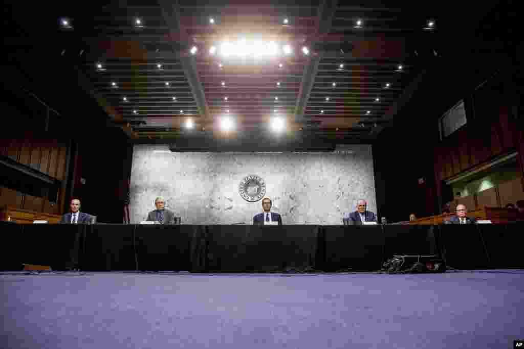 Lawmakers and officials keep space between themselves during a meeting to discuss the coronavirus relief bill on Capitol Hill in Washington.