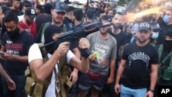 Supporters of the Shiite Amal group fire weapons in the air during the funeral processions of Hassan Jamil Nehmeh, who was killed during clashes the day before, in the southern Beirut suburb of Dahiyeh, Lebanon, Oct. 15, 2021.