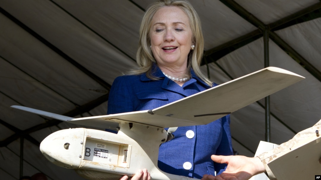 En esta foto la secretaria de Estado de EE.UU., Hillary Clinton, sostiene un drone usado en Uganda para encontrar y destruir explosivos que matan a soldados.