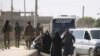 People gather along a road as they flee Raqqa, Syria, Oct. 16, 2017.