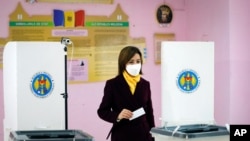 Former prime minister Maia Sandu prepares to cast her vote in the country's presidential election runoff in Chisinau, Moldova, Nov. 15, 2020. 