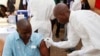 FILE - A health worker prepares to inject a man with an Ebola vaccine in Conakry, Guinea, March 7, 2015.