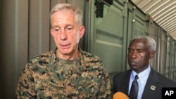 FILE - Gen. Thomas D. Waldhauser, left, commander of U.S. Africa Command, is joined by U.S. Ambassador to Senegal Tulinabo S. Mushingi, right, while speaking during a tour of a cooperative security location Camp Cisse, July 30, 2018. 