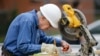 Former president Jimmy Carter measures before making a cut with a miter saw at a Habitat for Humanity building site, Nov. 2, 2015, in Memphis, Tennessee.