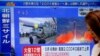 A woman walks past a TV screen broadcasting news of North Korea's missile launch, in Tokyo, Japan, Aug. 29, 2017. 