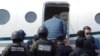 El expresidente de Honduras Juan Orlando Hernández, en el centro, con camisa azul y fuertemente escoltado por las fuerzas de seguridad, en el momento de su entrega a las autoridades estadounidenses en la base aérea de Tegucigalpa, el 21 de abril de 2022.