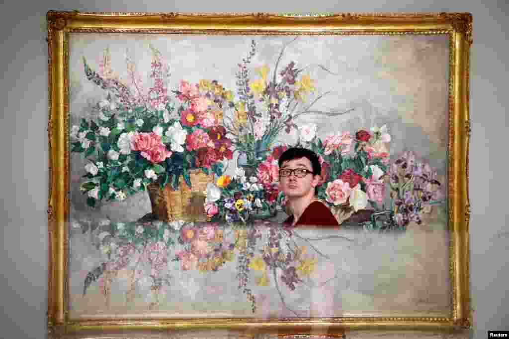 A visitor walks past the painting "Various Flowers" by Pyotr Konchalovsky at the Museum of Russian Impressionism in Moscow, Russia.