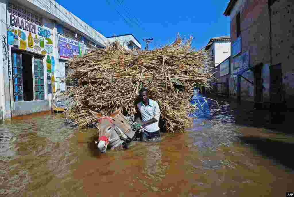 Seorang pria membawa keledainya melewati jalanan yang tergenang banjir di Beledweyne, utara ibukota Mogadishu, Somalia.