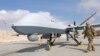 FILE - U.S. Air Force officer passes in front of a MQ-9 Reaper drone, one of a squadron that has arrived to step up the fight against the Taliban, at the Kandahar air base, Afghanistan, Jan. 23, 2018. 