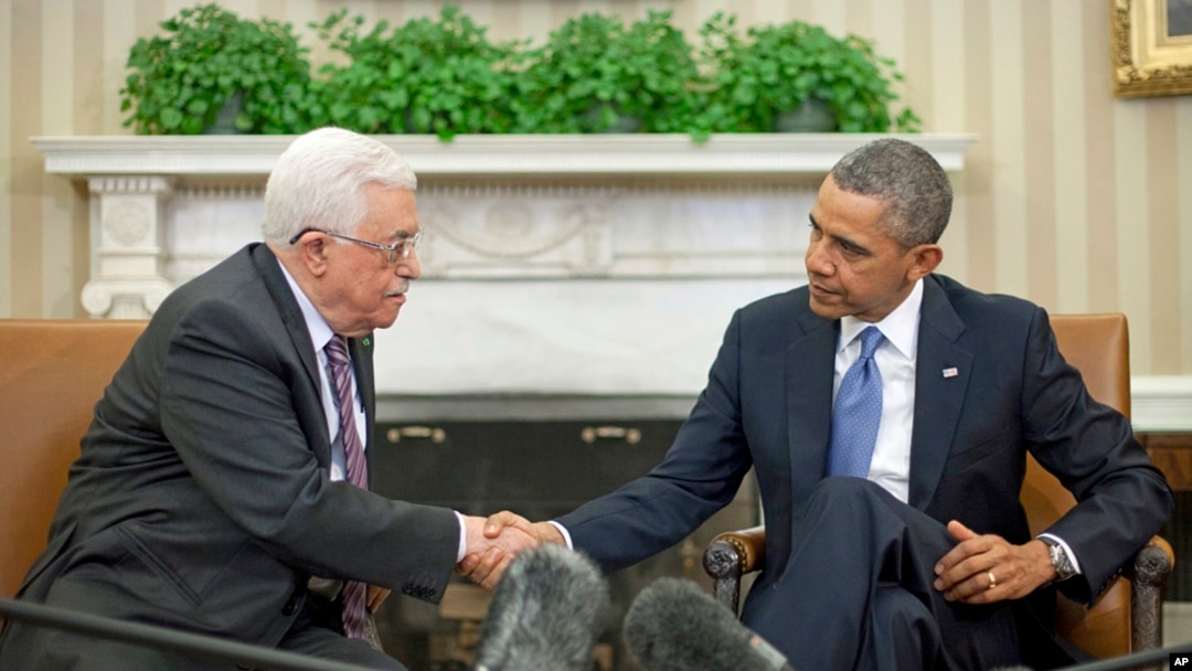 President Barack Obama (r) shakes hands with Palestinian President Mahmoud Abbas during their meeting in the Oval Office of the White House, March 17, 2014.