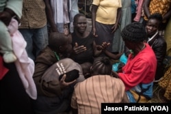 The mother of Duku Evans — who was killed November 3 amid fighting between government troops and rebels in Logo displaced persons camp in Kajo Keji, South Sudan — prays with her hands out during her son's funeral on the Ugandan border, Nov. 5, 2017.
