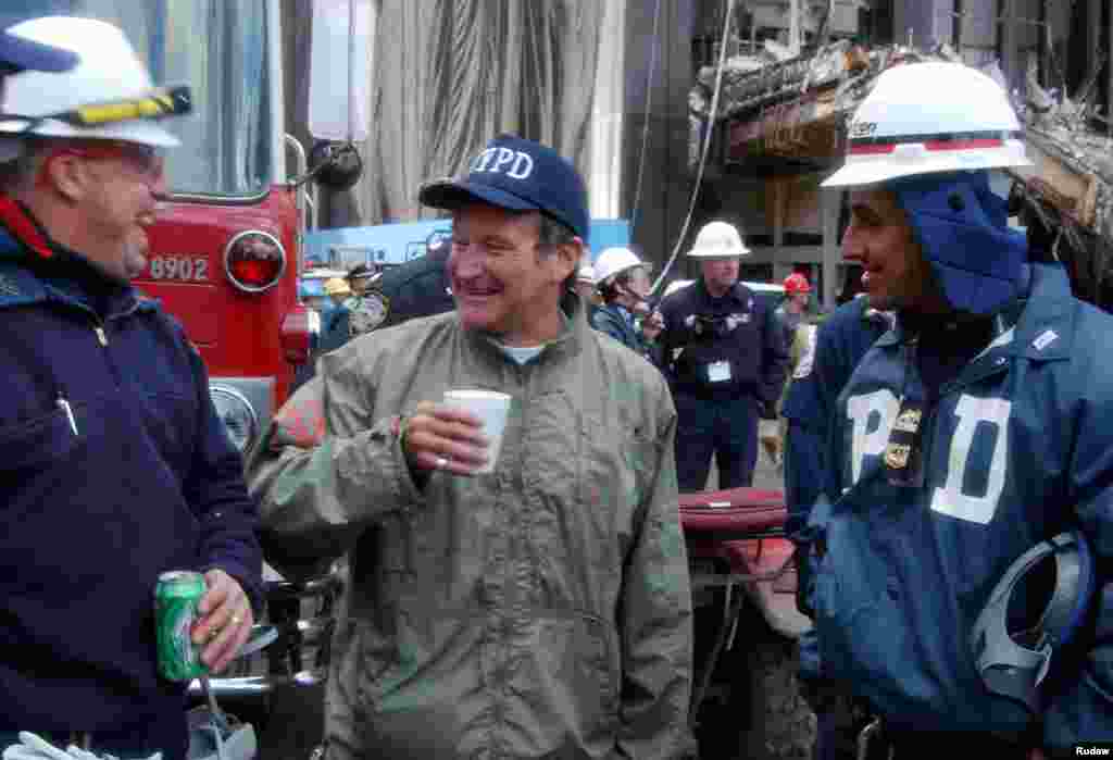 Actor and comedian Robin Williams (C) shares a laugh with rescue workers near the site of the World Trade Center collapse in lower Manhattan, Oct. 17, 2001. Williams spent time with rescue workers as well as surprising their wives with phone calls.