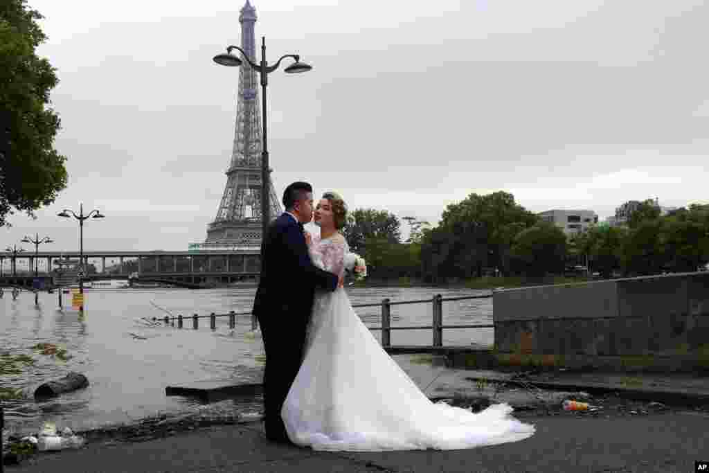 Sepasang pengantin baru China melakukan foto wedding di depan menara Eiffel, Paris, yang sayangnya sedang dilanda banjir akibat meluapnya sungai Seine.