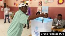 Um eleitor coloca o voto numa urna, em Luanda. 23 de Agosto, 2017. Angola