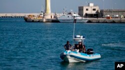 FILE - Italian police patrol a port in southern Italy, April 20, 2018. 