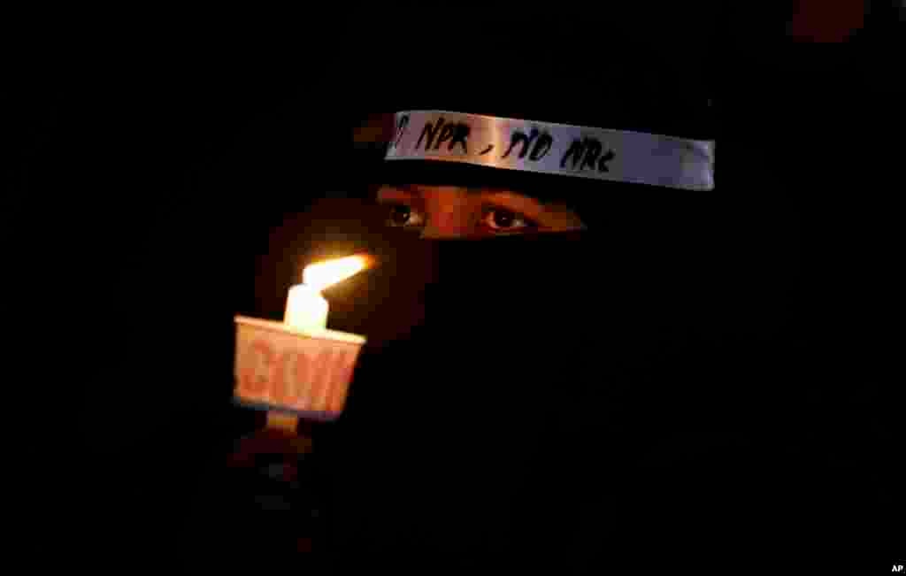 An Indian Muslim woman holds a candle during a protest against a new citizenship law that opponents say threatens India's secular identity in Bangalore, India.