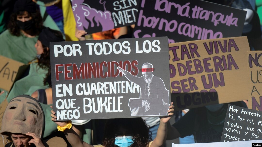 Activistas sostienen pancartas mientras participan en una marcha exigiendo el fin de la violencia contra las mujeres y el feminicidio en el país, antes de una protesta por el Día Internacional de la Mujer, en San Salvador, El Salvador, el 7 de marzo de 2021.