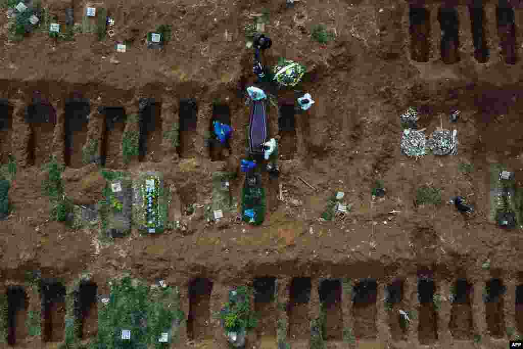 Gravediggers bury an alleged COVID-19 victim at the Vila Formosa Cemetery, in the outskirts of Sao Paulo, Brazil.