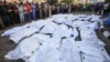 Palestinci iznad prekrivenih tela ubijenih u izraelskim bombardovanjima u Deir Balahu u centralnom delu Pojasa Gaze, u bolnici Šuhada al-Aksa, 6. novembra 2023.