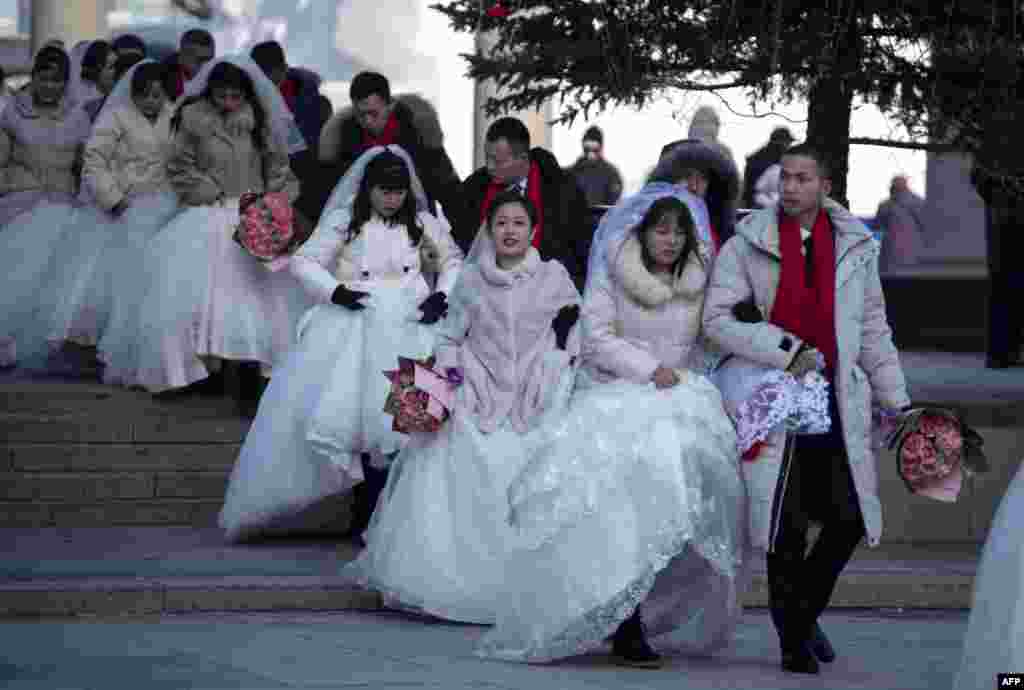 Couples arrive for a "mass ice and snow wedding" ahead of the opening of the Harbin International Snow and Sculpture Festival in Harbin, in China's northeast Heilongjiang province.