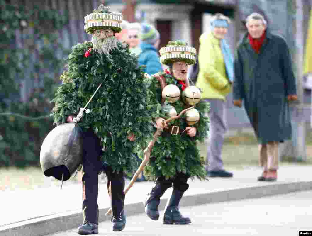 Men dressed as "Chlaeuse", figures that scare away evil spirits, carry round bells and cowbells during the traditional "Sylvesterchlausen" in near the northeastern village of Urnaesch, Switzerland.