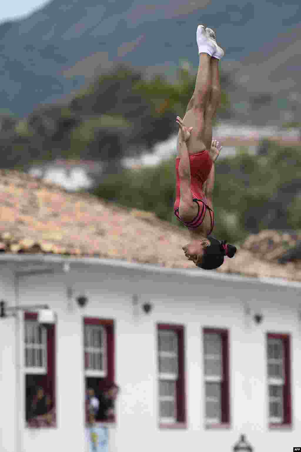 Anak-anak Aleijadinho Foundation berlatih dengan trampolin dalam persiapan menyambut kedatangan obor Olimpiade di kota bersejarah Ouro Preto di Minas Gerais, Brazil.