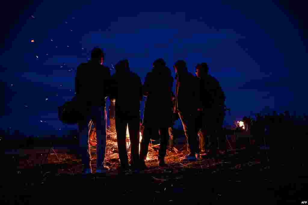 Migrants light a fire while camping along the Turkey-Greece border near Pazarkule, in Edirne district, Turkey.