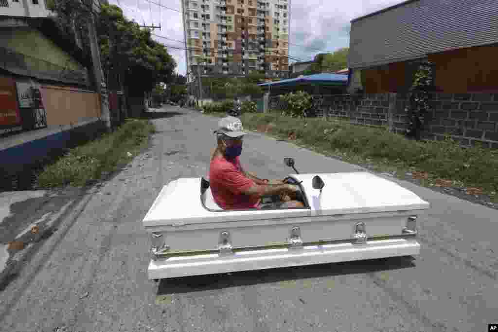 Gabriel Berendo, a businessman and car enthusiast, drives a casket converted into a car in Cebu city, central Philippines, as he goes around streets to remind residents to stay at home as lockdown measures to prevent the spread of the COVIA-19.
