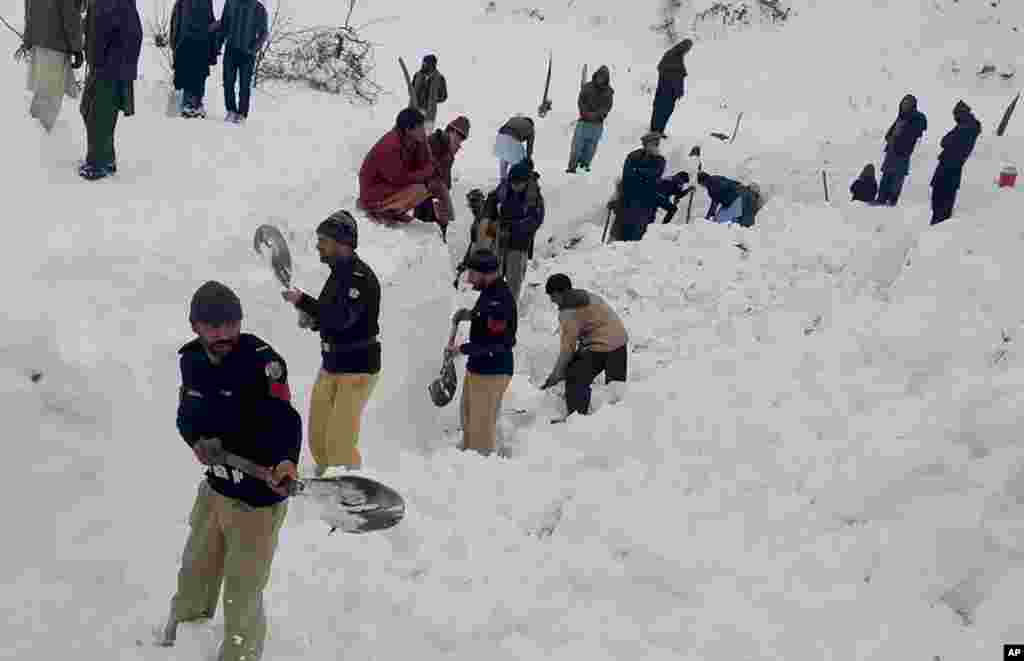 Police officers and local residents dig to search bodies of victims of avalanches in Doodnail village in Neelum Valley, Pakistan-administered Kashmir. Search teams aided by Pakistani troops pulled out 21 more bodies from homes destroyed by this week's avalanches in the disputed Himalayan region of Kashmir, officials said.