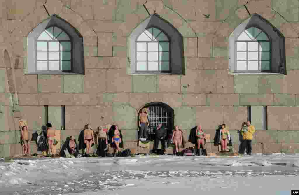 People sunbathe at the wall of the Peter and Paul Fortress in Saint Petersburg, Russia.