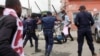 Polícias bate em manifestantes em Luanda, quando estes participavam numa manifestação contra o desemprego, uma das áreas que evidenciam a corrupção.