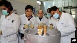 IAEA 관계자들과 이란 기술자들이 지난 1월 이란 테헤란 남쪽 나탄즈 핵 시설에서 고농축 우라늄 생산용 원심분리기 작동을 중단시키고 있다.