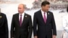 Russian President Vladimir Putin, left, and Chinese President Xi Jinping line up for a photo during the BRICS Summit in southeastern China's Fujian province, Sept. 4, 2017.