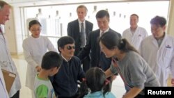 Activista chinês Chen Guangcheng num hospital de Pequim na companhia de sua família e sob o olhar responsáveis do Departamento do Estado norte-americano