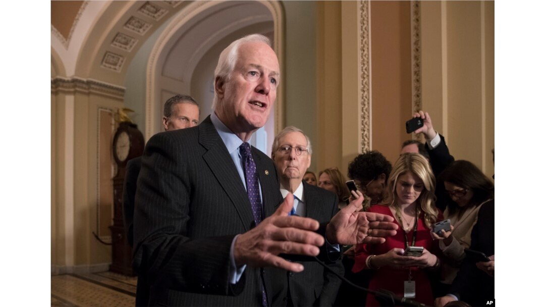 FILE - Senate Majority Whip John Cornyn, R-Texas, flanked by Sen. John Thune, R-S.D., left, and Senate Majority Leader Mitch McConnell, R-Ky., talks to reporters following weekly policy luncheons where they discussed school safety measures in response to the Parkland, Fla., assault that left 17 dead, at the Capitol in Washington, Feb. 27, 2018.