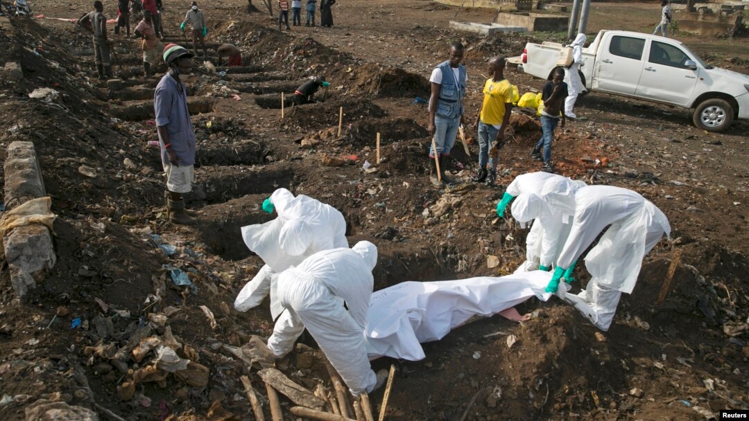 Health workers bury the body of a suspected Ebola victim at a cemetery in Freetown, Dec. 21, 2014. 